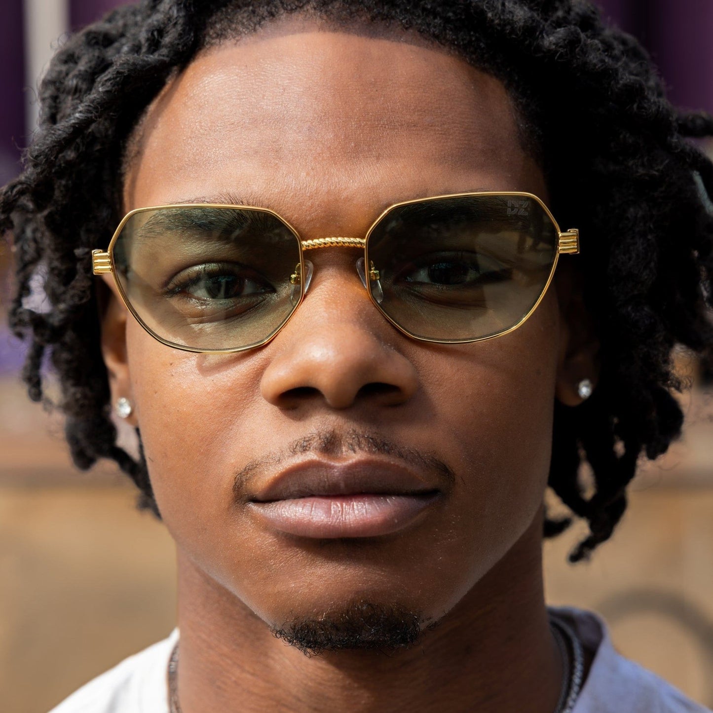 Person wearing gold sunglasses with a blurred background