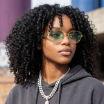 Woman wearing sunglasses and a gray hoodie with a blurred background